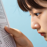 ** A close-up of a focused student carefully reading a TOPIK exam question. Emphasis on concentration, perhaps with light highlighting specific words in the question. Subtle hints of test anxiety (e.g., a slightly furrowed brow) balanced with a determined expression. Keywords: TOPIK exam, reading comprehension, focus, test preparation, Korean language.

**